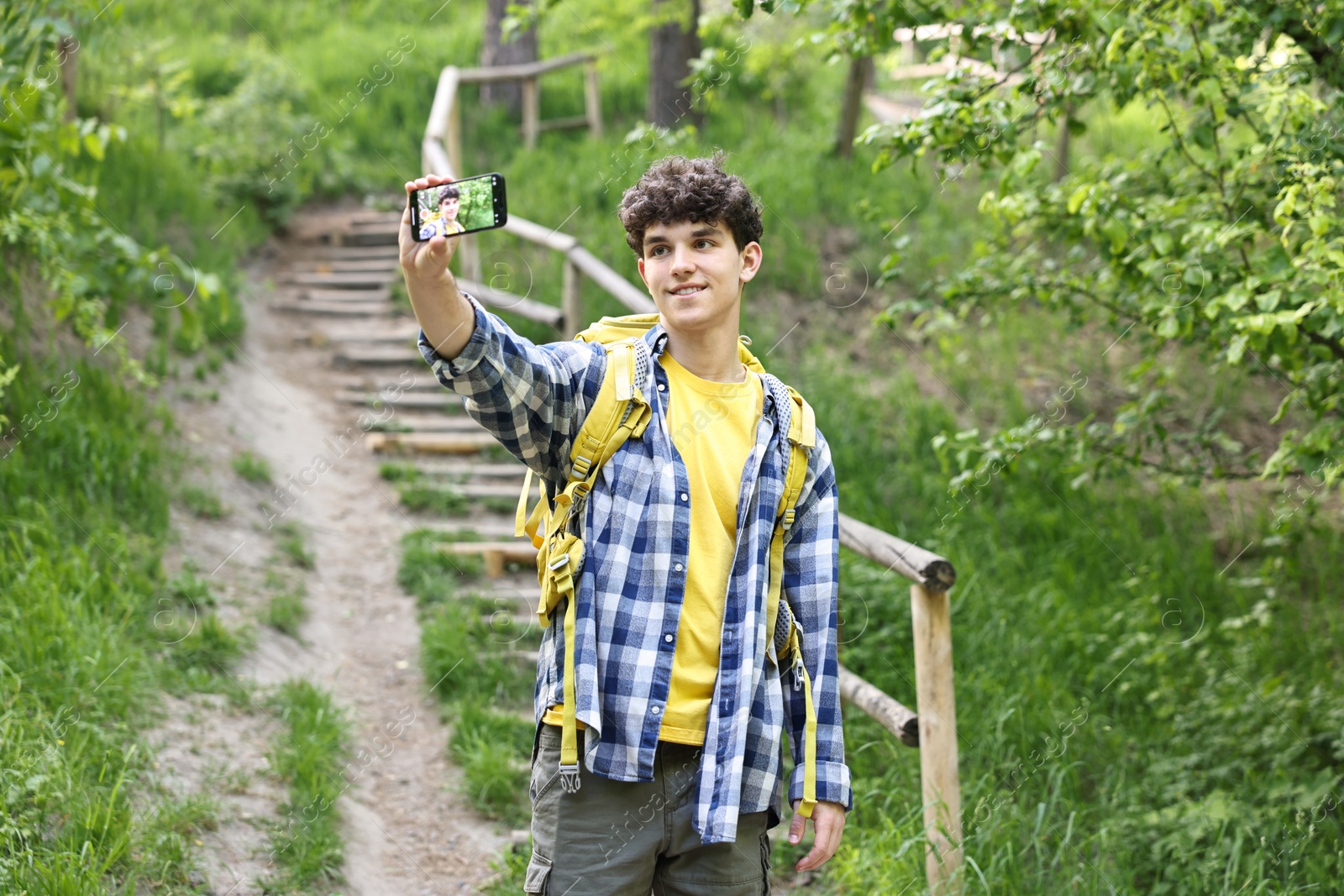 Photo of Smiling travel blogger with smartphone streaming outdoors