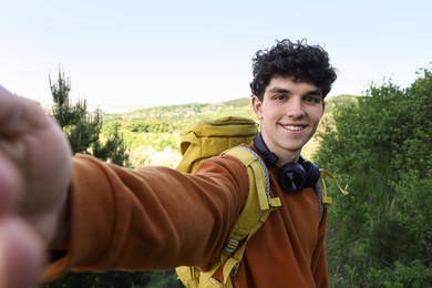 Travel blogger with headphones takIng selfie outdoors