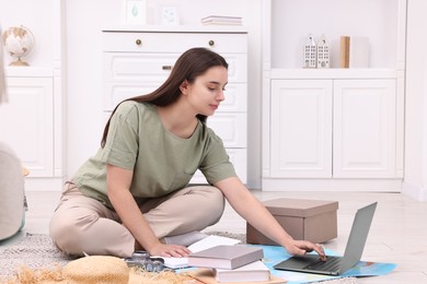 Photo of Travel blogger using laptop for planning trip at home