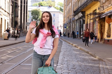 Travel blogger recording video on city street, space for text