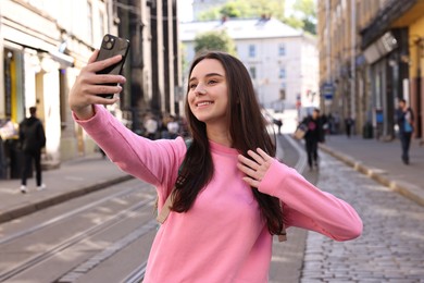 Photo of Travel blogger with smartphone streaming on city street