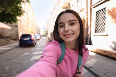 Photo of Travel blogger takIng selfie on city street