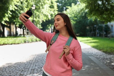 Travel blogger takIng selfie with smartphone outdoors