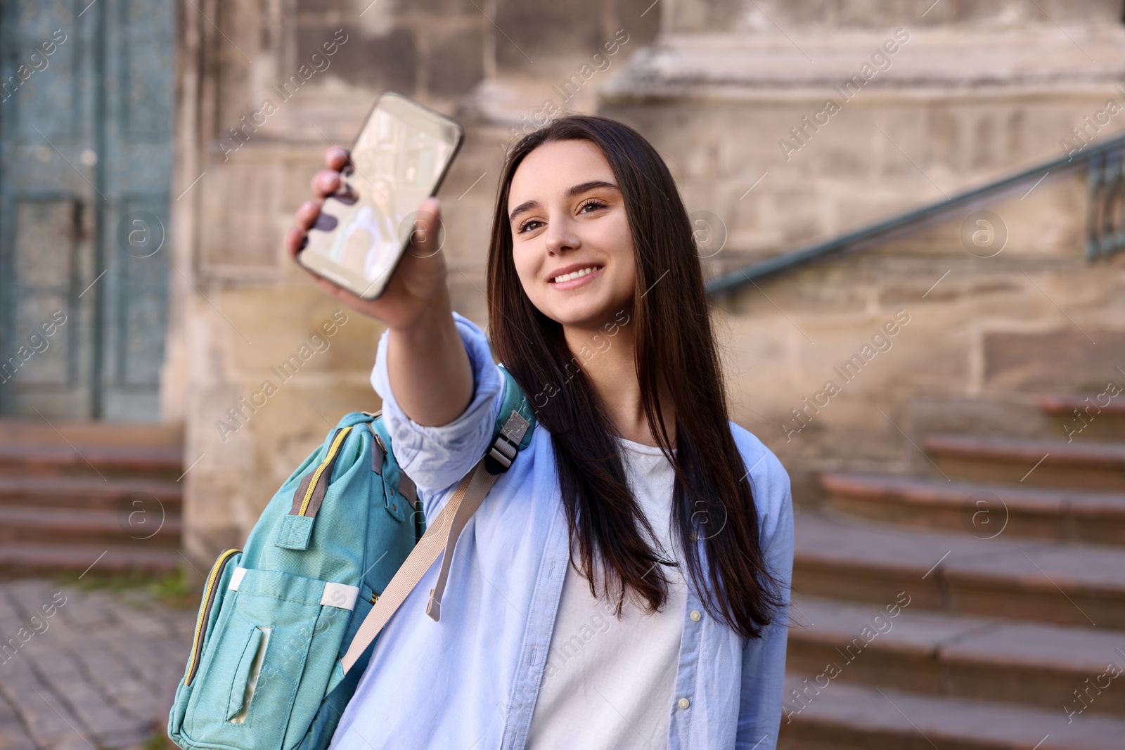 Photo of Beautiful travel blogger with smartphone streaming outdoors