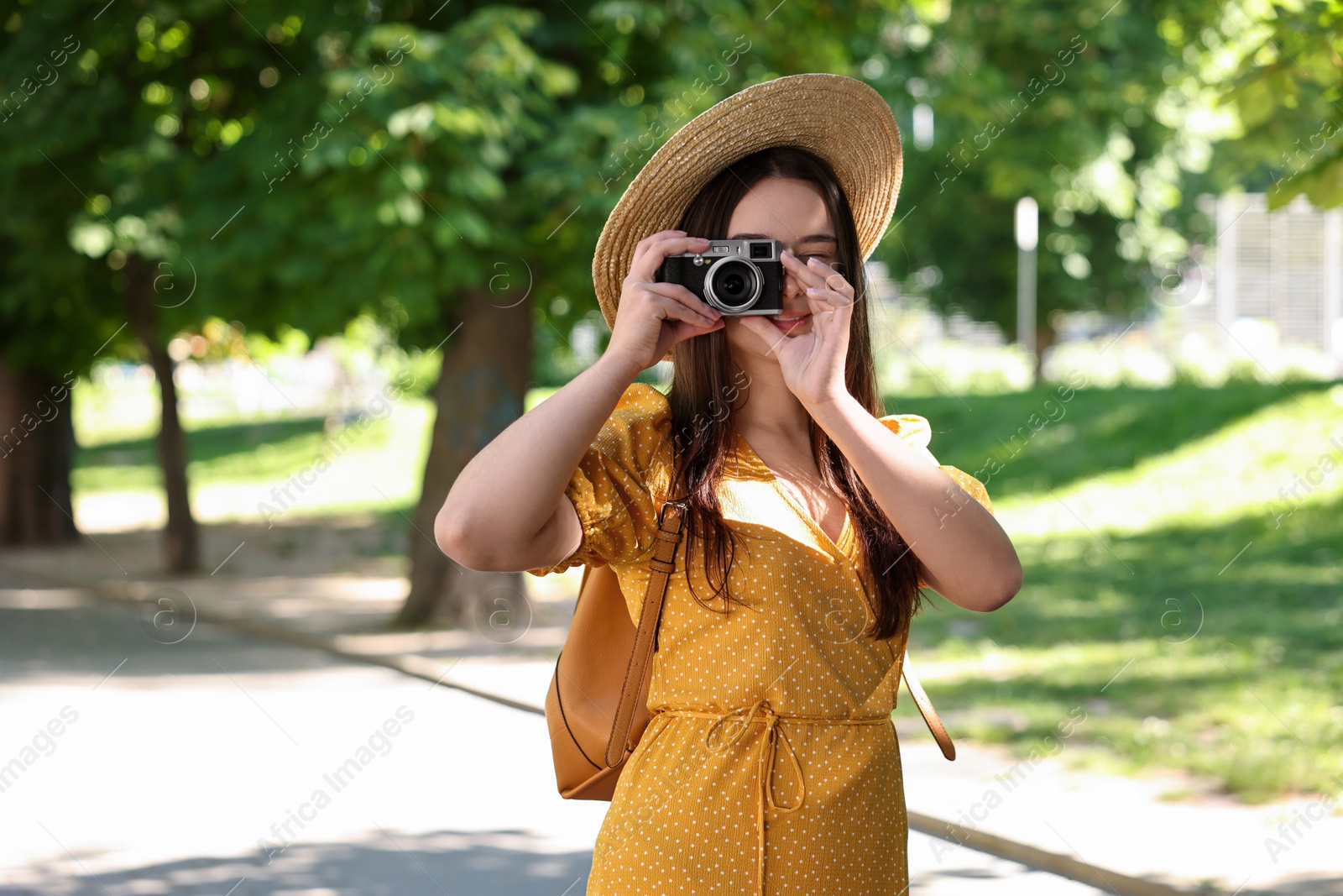 Photo of Travel blogger takIng picture with vintage camera in park