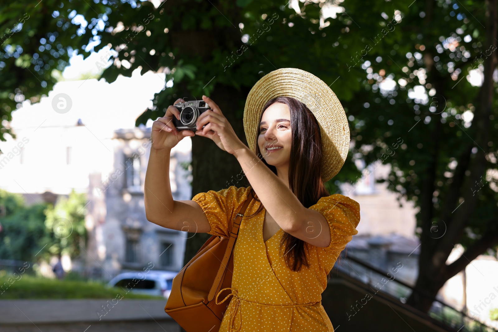 Photo of Travel blogger takIng picture with vintage camera outdoors