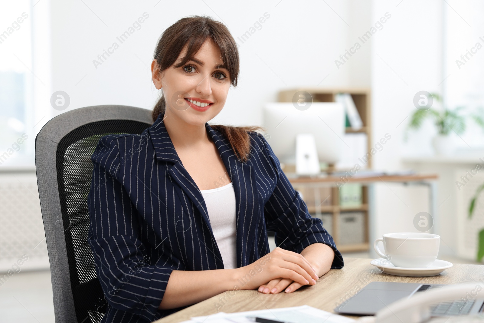 Photo of Portrait of smiling secretary at table in office