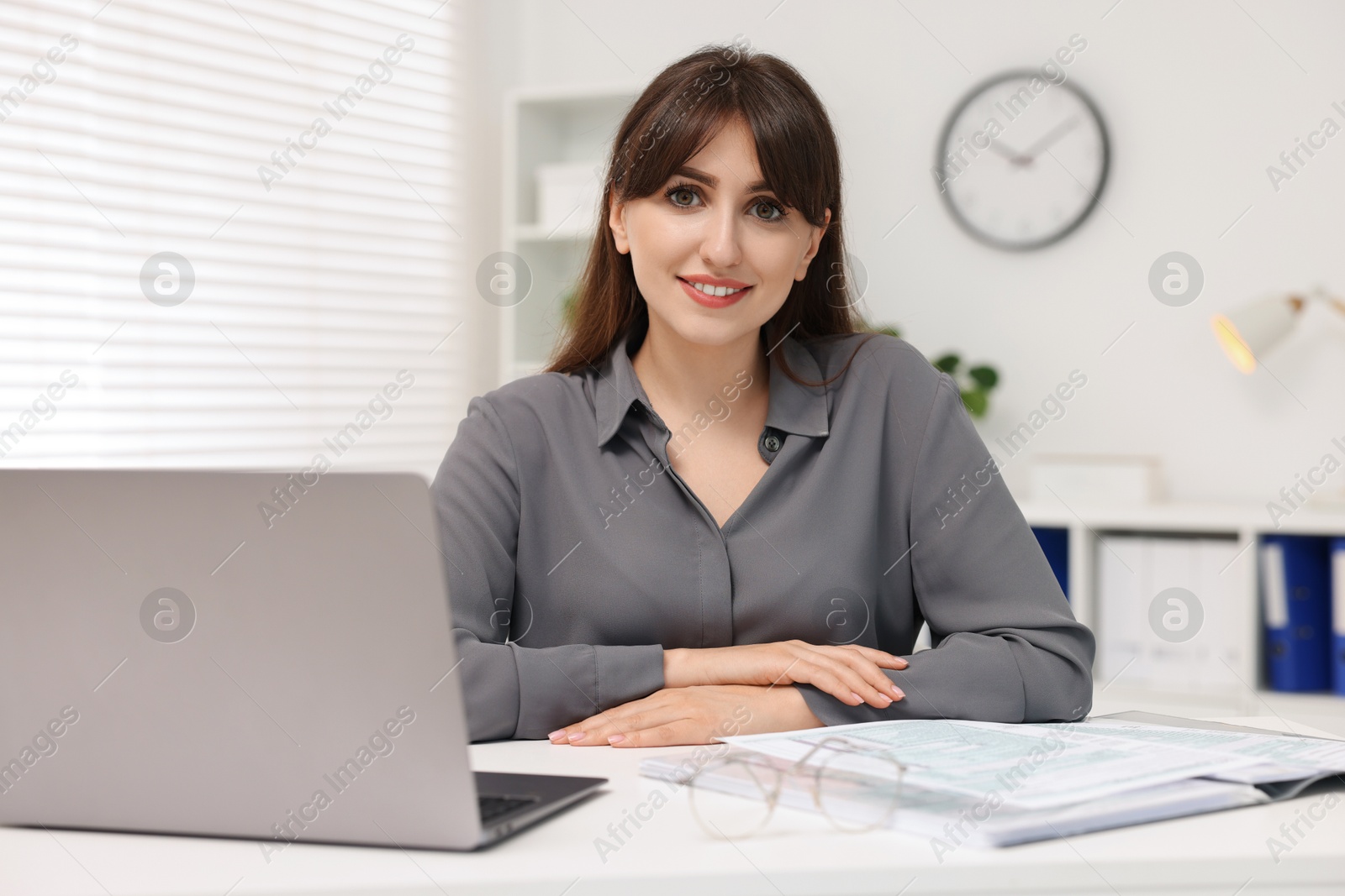 Photo of Portrait of smiling secretary at table in office