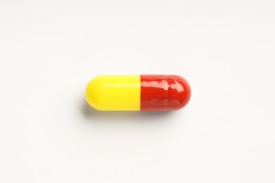 Photo of One antibiotic pill on white background, top view