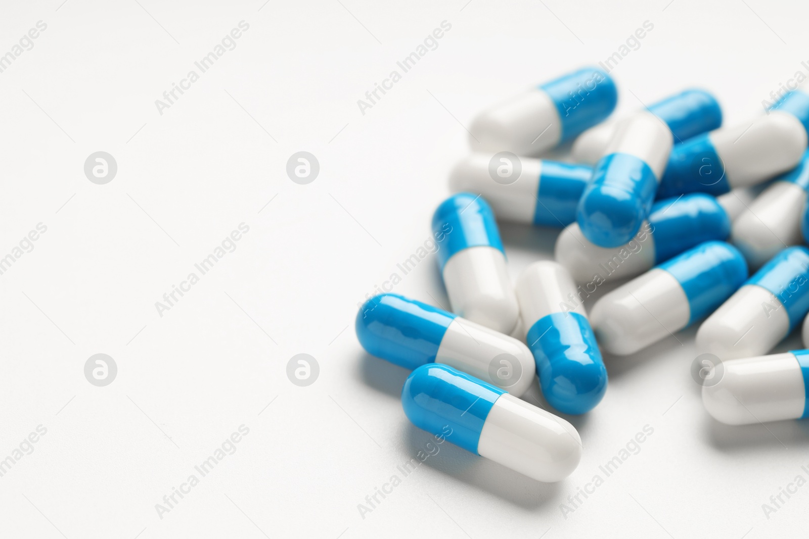 Photo of Antibiotic pills on white background, closeup. Space for text