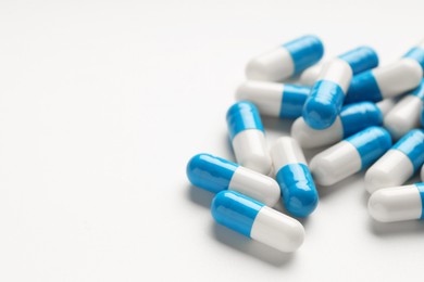 Antibiotic pills on white background, closeup. Space for text