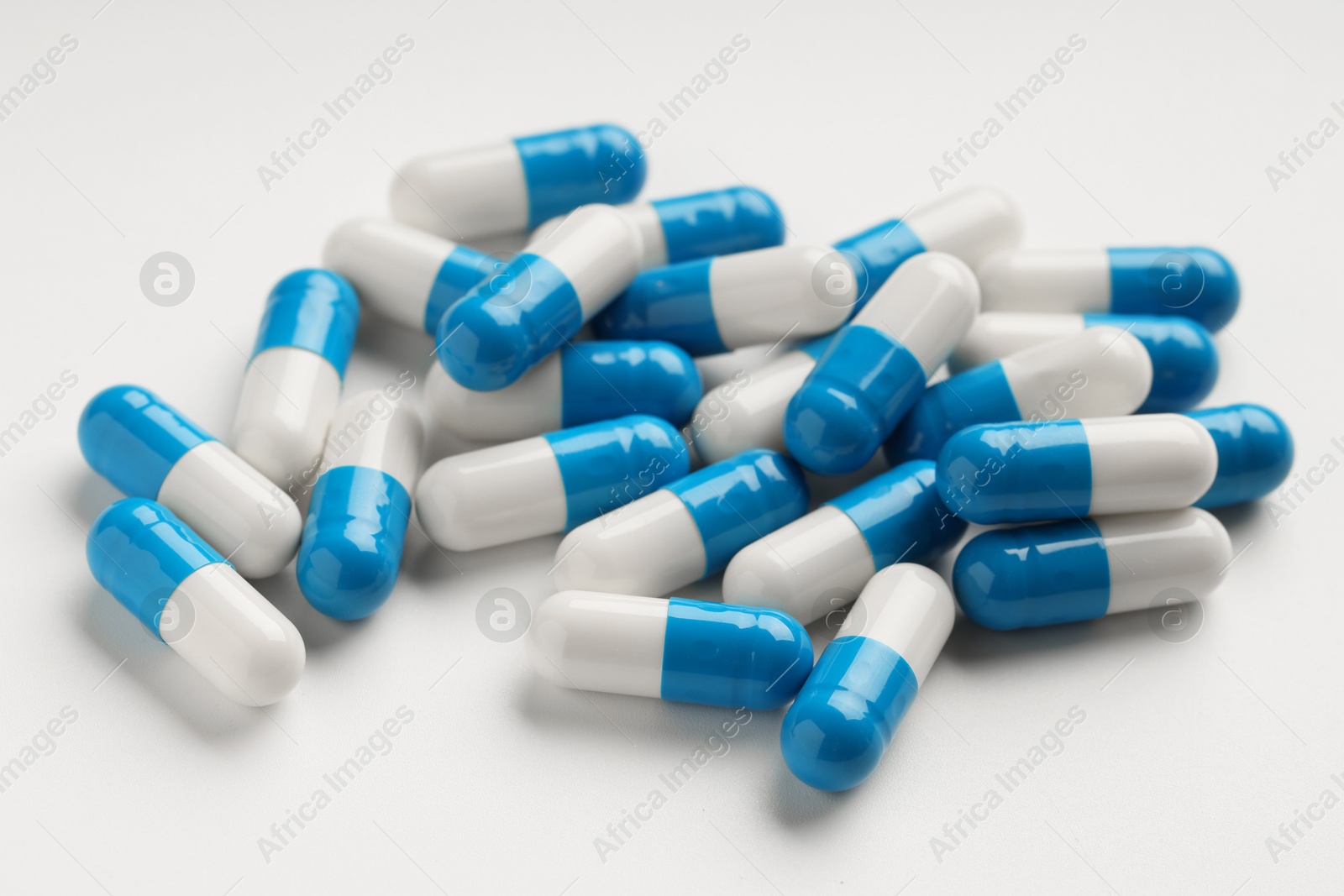 Photo of Many antibiotic pills on white background, closeup