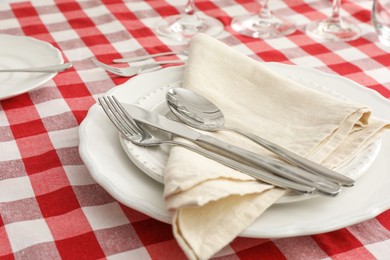 Stylish setting with cutlery, plates and napkin on table, closeup