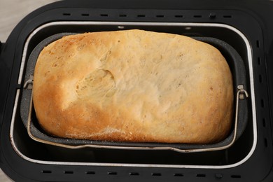 Photo of Fresh homemade bread in open breadmaker machine, above view