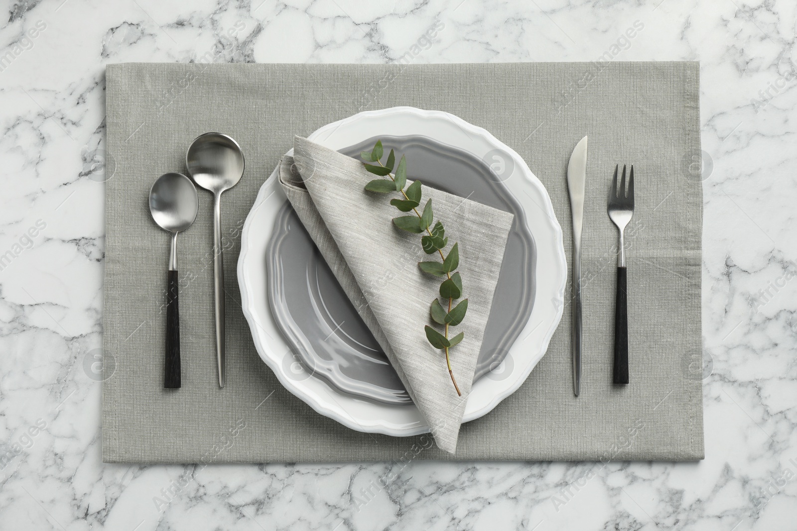 Photo of Stylish setting with cutlery and plates on white marble table, flat lay