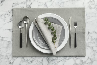 Photo of Stylish setting with cutlery and plates on white marble table, flat lay