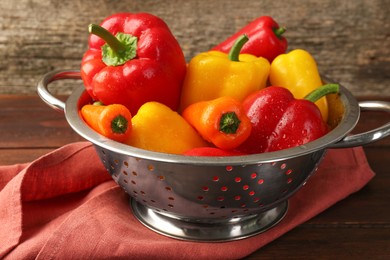 Photo of Metal colander with fresh peppers on table, closeup