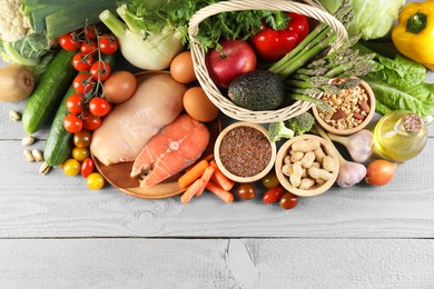 Healthy food. Basket with different fresh products on grey wooden table, flat lay. Space for text