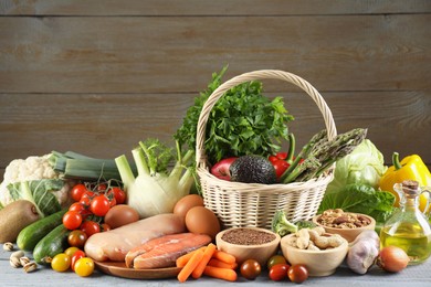 Photo of Healthy food. Basket with different fresh products on grey table