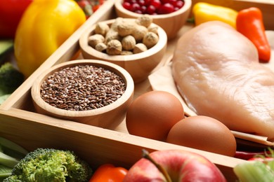 Raw chicken, eggs, fruits, seeds and other healthy food, closeup