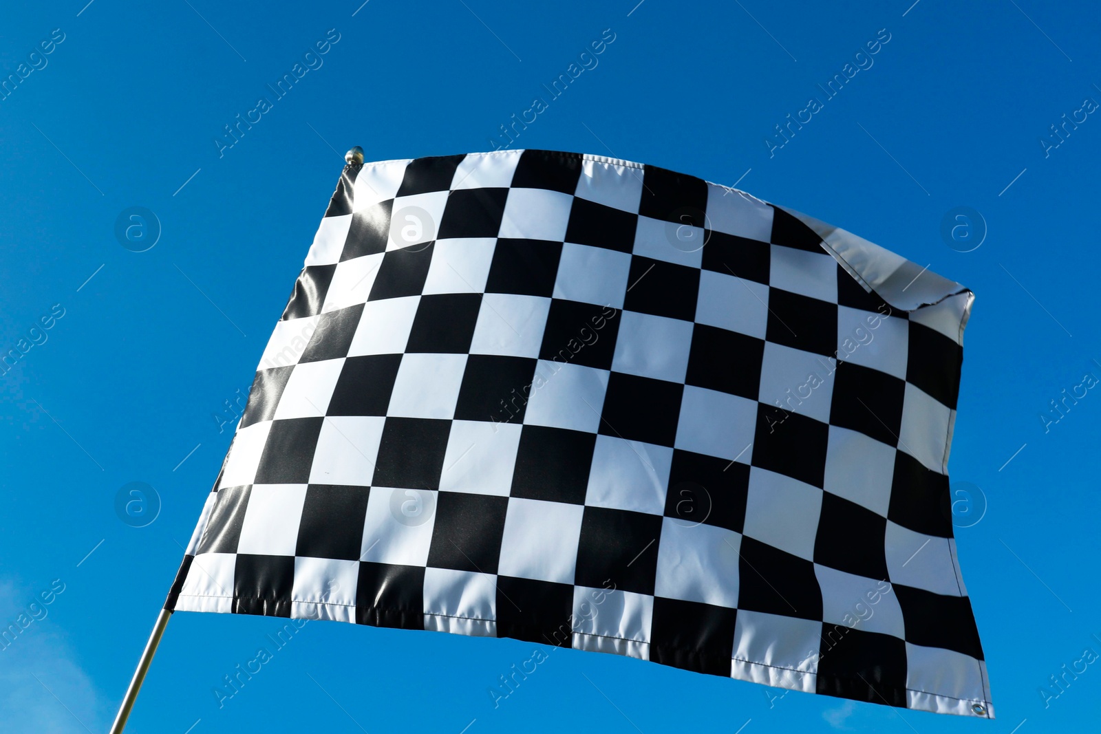 Photo of Checkered flag against blue sky outdoors, low angle view. Space for text