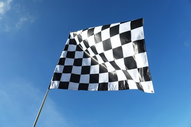 Checkered flag against blue sky outdoors, low angle view