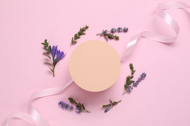 Photo of Beautiful ribbon and round shaped podium on pink background, flat lay