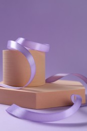 Beautiful ribbon and different podiums on violet background, closeup