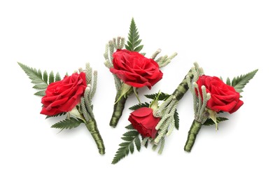 Many stylish red boutonnieres isolated on white, top view