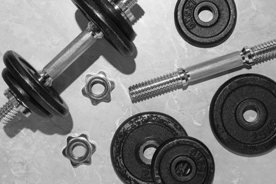 Photo of Barbell and parts of one on grey floor, flat lay