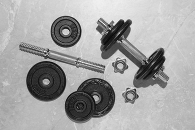 Photo of Barbell and parts of one on grey floor, flat lay