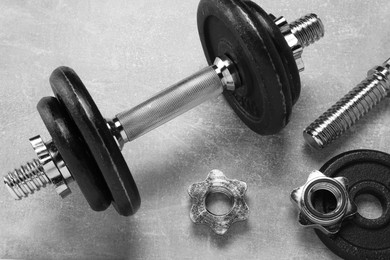 Photo of Barbell and parts of one on grey textured background, flat lay