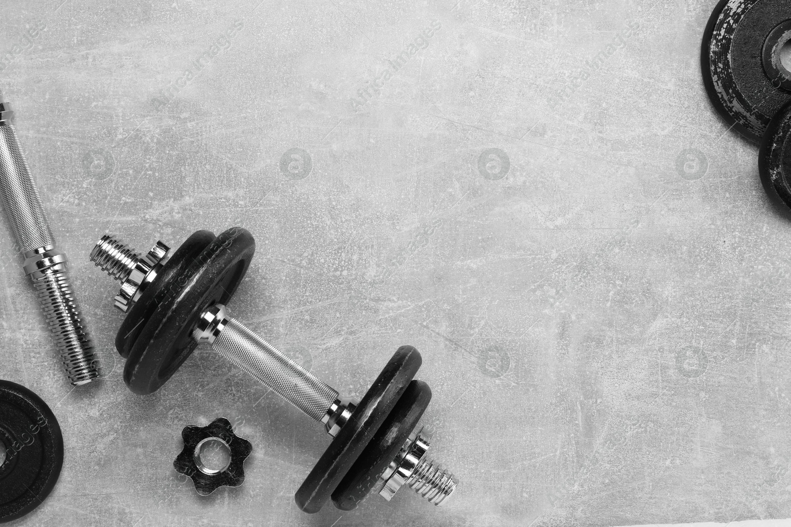 Photo of Barbell and parts of one on grey textured background, flat lay. Space for text