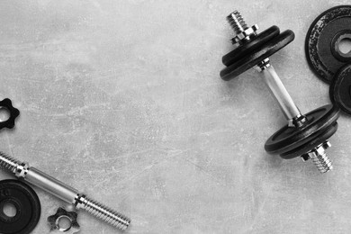 Photo of Barbell and parts of one on grey textured background, flat lay. Space for text