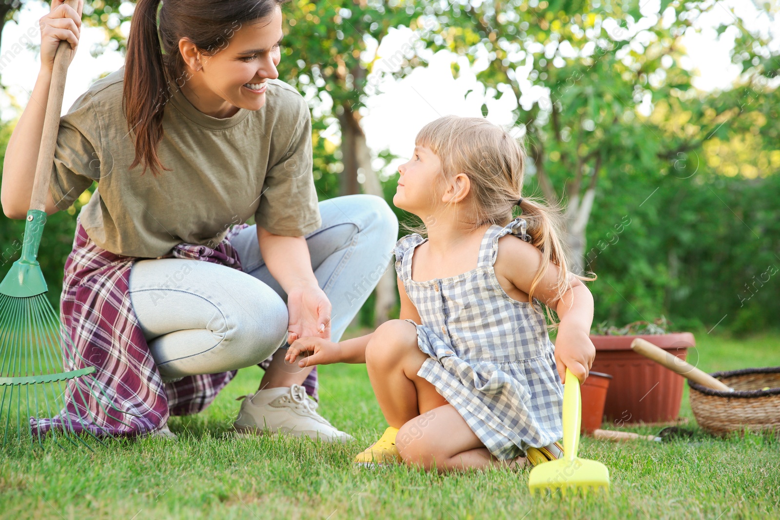 Photo of Mother and her daughter working together in garden