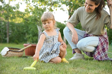 Photo of Mother and her daughter working together in garden