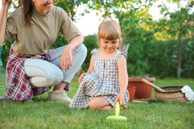 Photo of Mother and her daughter working together in garden