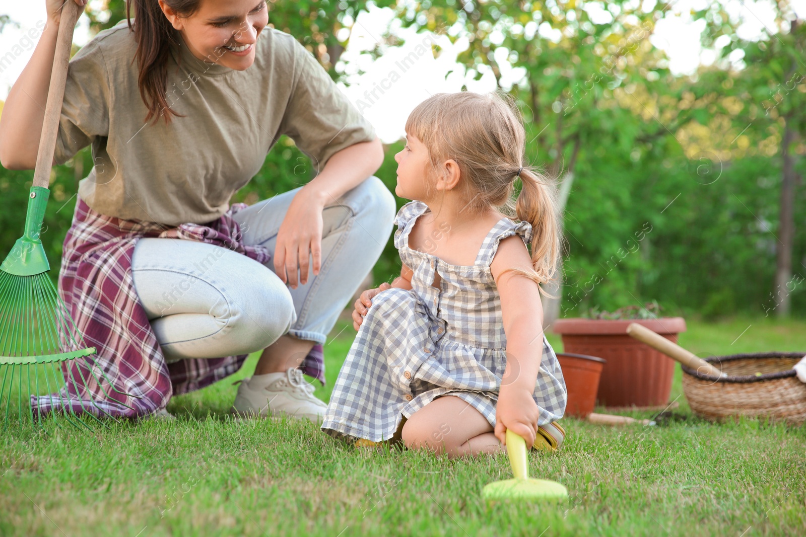 Photo of Mother and her daughter working together in garden