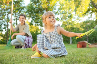 Photo of Mother and her daughter working together in garden