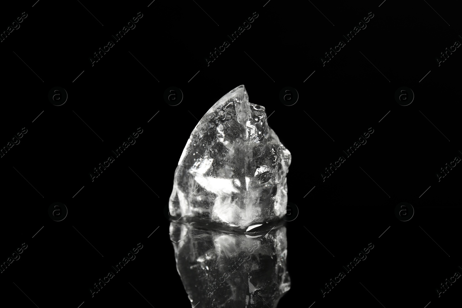 Photo of Piece of clear ice on black mirror surface