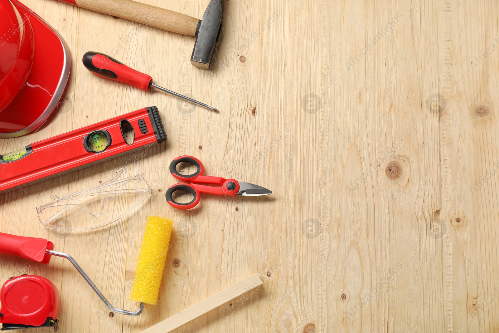 Photo of Flat lay composition with building level and other different construction tools on wooden background, space for text