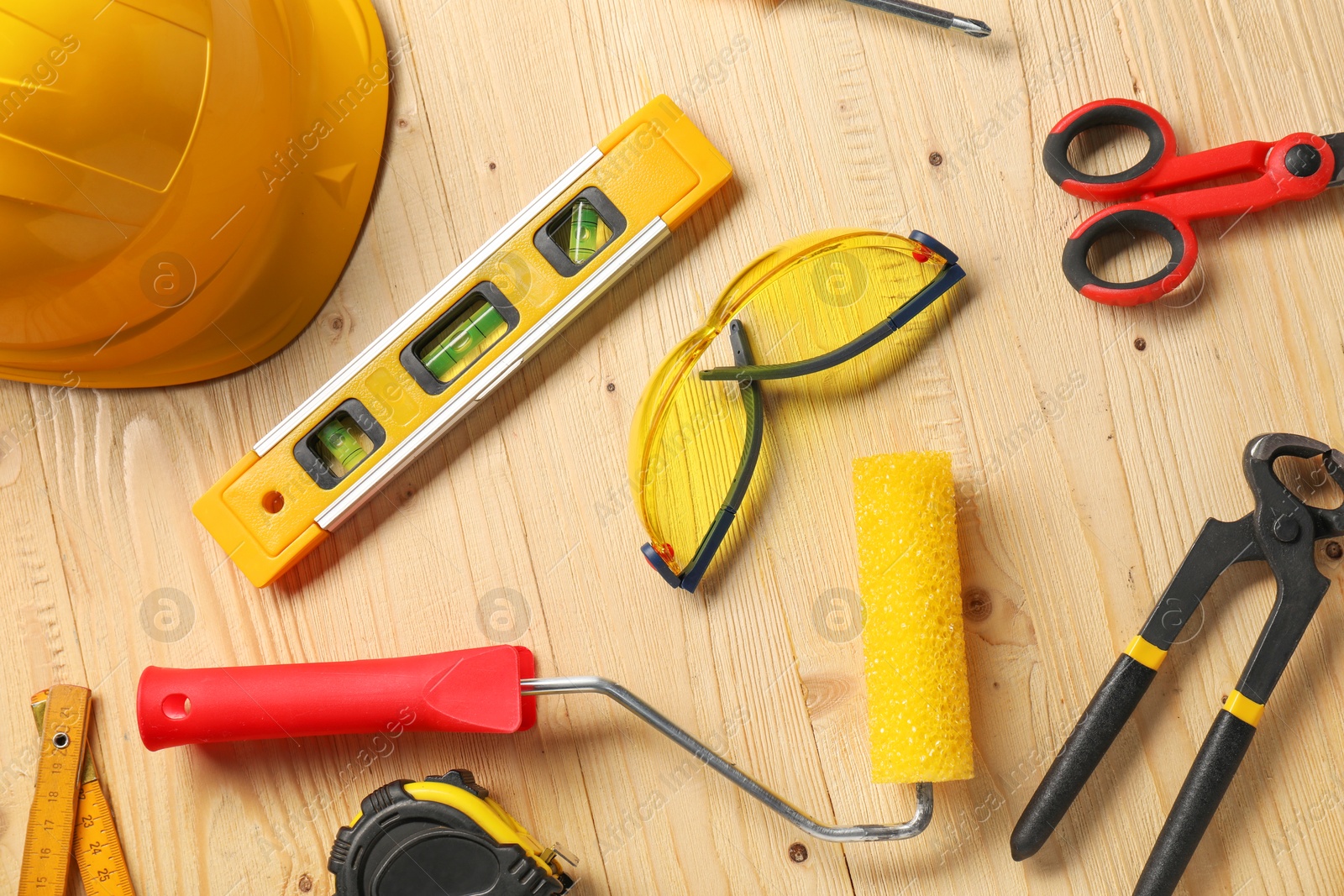 Photo of Flat lay composition with building level and other different construction tools on wooden background