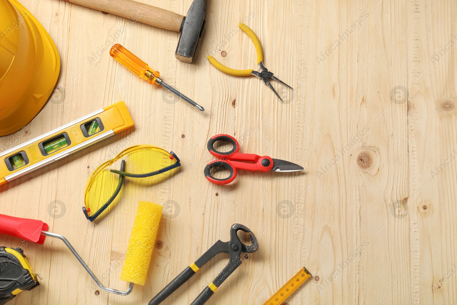 Photo of Flat lay composition with building level and other different construction tools on wooden background, space for text