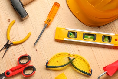 Photo of Flat lay composition with building level and other different construction tools on wooden background