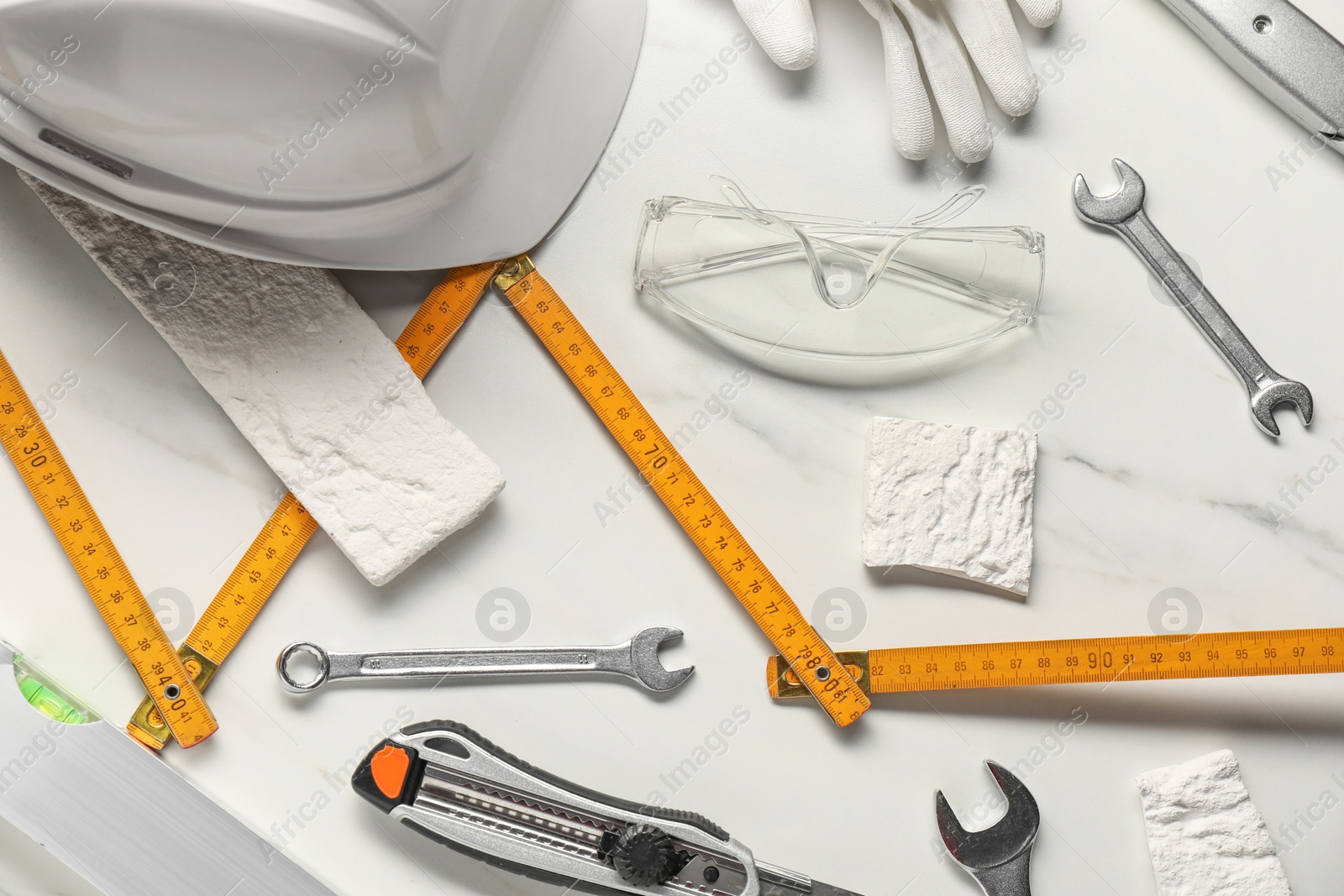 Photo of Flat lay composition with different construction tools on white marble background