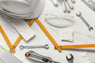 Photo of Flat lay composition with different construction tools on white marble background