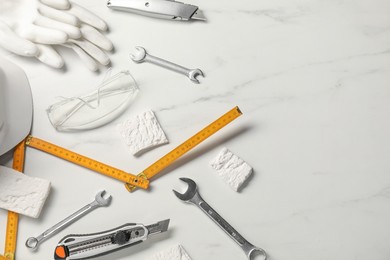 Photo of Flat lay composition with different construction tools on white marble background, space for text