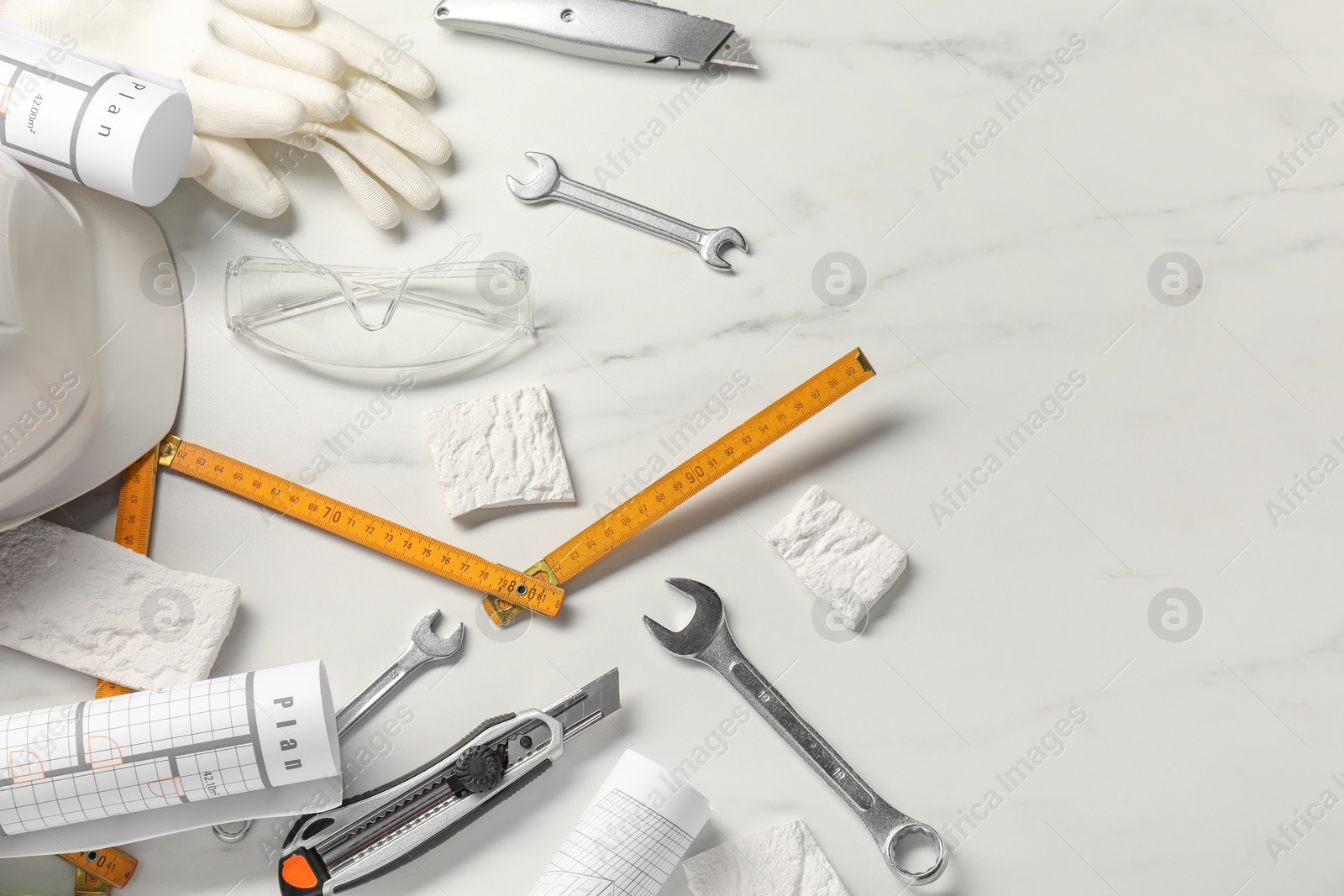 Photo of Flat lay composition with different construction tools on white marble background, space for text