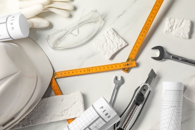 Flat lay composition with different construction tools on white marble background