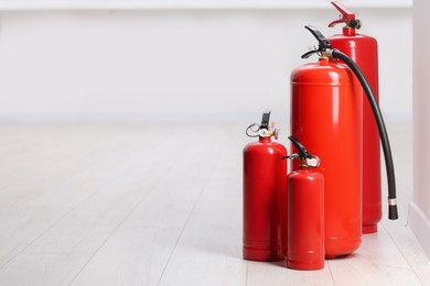 Photo of Fire extinguishers on floor indoors, space for text